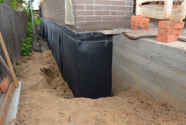 SJ Waterproofing Pros technician performing targeted Wet Basement Repair assessment in Oconomowoc, WI